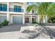 Modern home with attached garage and tropical landscaping at 6530 Peacock Rd, Sarasota, FL 34242