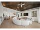 Open living room with a curved sofa and dark wood ceiling at 6530 Peacock Rd, Sarasota, FL 34242