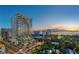 Aerial view of a modern high-rise building at sunset, offering stunning water views at 668 Quay Commons # 1102, Sarasota, FL 34236