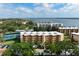 Aerial view of condo building with tennis courts and lush landscaping at 8773 Midnight Pass Rd # 205G, Sarasota, FL 34242