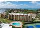 Aerial view of condo building with pool and tennis courts nearby at 8773 Midnight Pass Rd # 205G, Sarasota, FL 34242