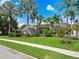 Single-story home with tile roof, lush landscaping, and palm trees at 9052 Misty Creek Dr, Sarasota, FL 34241