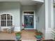 Front porch with blue double doors, terracotta tile floor, and potted plants at 9052 Misty Creek Dr, Sarasota, FL 34241