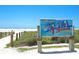 Siesta Beach entrance sign; white sand beach in background at 9085 Bernini Pl, Sarasota, FL 34240