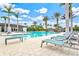 Large swimming pool surrounded by lounge chairs and palm trees at 9085 Bernini Pl, Sarasota, FL 34240