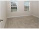 Bright bedroom with neutral carpeting and two large windows at 9814 Daybreak Gln, Parrish, FL 34219