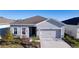 Gray house with two car garage and landscaped yard at 9814 Daybreak Gln, Parrish, FL 34219