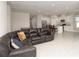 Open concept living room with dark leather sectional sofa at 9814 Daybreak Gln, Parrish, FL 34219