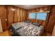 Bedroom with twin beds, wood-paneled walls, and wood floors at 10315 Cortez W Rd # 37F, Bradenton, FL 34210