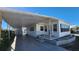 Front view of a white mobile home with carport and landscaping at 10315 Cortez W Rd # 37F, Bradenton, FL 34210