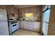 Galley kitchen with white appliances and wood cabinets at 10315 Cortez W Rd # 37F, Bradenton, FL 34210
