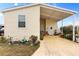 Tan mobile home with covered entryway and landscaping at 1106 49Th Avenue W Dr, Bradenton, FL 34207