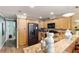 Bright kitchen with light wood cabinets, granite countertops, and stainless steel appliances at 1106 49Th Avenue W Dr, Bradenton, FL 34207
