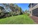 Landscaped backyard with lush green grass and mature trees at 12413 Osorio Ct Ct # 103, Sarasota, FL 34238