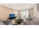 Comfortable living room with gray sofa and access to screened patio at 12413 Osorio Ct # 103, Sarasota, FL 34238
