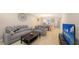 Open concept living room with gray sectional and flat screen TV at 12413 Osorio Ct # 103, Sarasota, FL 34238