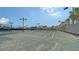 Outdoor tennis courts with nets and lights at 12413 Osorio Ct # 103, Sarasota, FL 34238