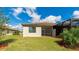 Rear exterior view of the home with a private screened-in patio and beautiful landscaping at 12651 Garibaldi Ln, Venice, FL 34293