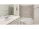 Well-lit bathroom with vanity, gray-tiled backsplash and shower, plus ample counter space at 12651 Garibaldi Ln, Venice, FL 34293