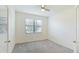 Light-filled bedroom with plush carpet, ceiling fan, neutral walls, and a window with blinds at 12651 Garibaldi Ln, Venice, FL 34293