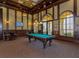 Spacious game room with billiard table, wood trim, elegant lighting and comfortable seating at 12651 Garibaldi Ln, Venice, FL 34293
