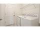 Practical laundry room with white appliances, shelving, and a door leading to the rest of the house at 12651 Garibaldi Ln, Venice, FL 34293