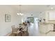 Bright living room with tile floors, natural light, dining table, and a view of the outdoor space at 12651 Garibaldi Ln, Venice, FL 34293