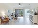 Inviting living room featuring tile floors, a comfortable sofa, and access to the screened lanai at 12651 Garibaldi Ln, Venice, FL 34293