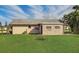 Back exterior showing additional structure and grassy yard at 13457 Muriel Ave, Port Charlotte, FL 33981