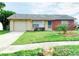 Brick ranch home with attached garage and well-maintained lawn at 13457 Muriel Ave, Port Charlotte, FL 33981