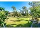 Landscaped backyard with lush lawn and tropical plants at 144 Tournament Rd, Rotonda West, FL 33947