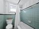 Bathroom with light teal tile and shower/tub combo at 1620 Casey Key Rd, Nokomis, FL 34275