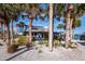 Cute beachfront bungalow nestled amongst palm trees, showcasing curb appeal at 1620 Casey Key Rd, Nokomis, FL 34275