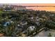 Aerial view of a neighborhood with mature trees, a parking lot, and a glimpse of the city skyline in the background at 1695 Lowe Dr, Sarasota, FL 34236