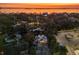 Sunset view of a neighborhood with mature trees, a parking lot, and a glimpse of the bay in the background at 1695 Lowe Dr, Sarasota, FL 34236