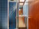 Retro bathroom with blue tile, walk-in shower, and stainless steel vanity at 1695 Lowe Dr, Sarasota, FL 34236