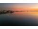 Scenic waterfront view with cityscape silhouetted against a vibrant sunset sky, reflecting on the calm water at 1695 Lowe Dr, Sarasota, FL 34236