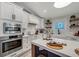 Modern kitchen with white cabinets, stainless steel appliances, and quartz countertops at 2208 Avenue A, Bradenton Beach, FL 34217