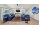 Bright living room with blue sofas, wood floors, and a large TV at 2208 Avenue A, Bradenton Beach, FL 34217