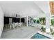 Covered patio with dining table and lounge chairs near the pool at 2208 Avenue A, Bradenton Beach, FL 34217