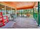 Screened porch with wooden flooring, rocking chair, and wooden ceiling at 29199 Livingston Dr, Punta Gorda, FL 33982