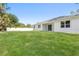 Spacious backyard with lush green grass and a white fence at 3490 Ikola Ave, North Port, FL 34288