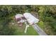 Aerial view of two dilapidated structures on a grassy lot surrounded by trees at 39200 Cook Brown Rd, Punta Gorda, FL 33982