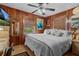 Main bedroom with wood-paneled walls, a king-size bed, and a TV at 39200 Cook Brown Rd, Punta Gorda, FL 33982