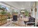 Relaxing screened porch with wooden deck, comfortable seating, and lush greenery views at 39200 Cook Brown Rd, Punta Gorda, FL 33982
