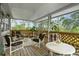 Spacious screened porch features wooden deck, comfortable seating and tranquil wooded views at 39200 Cook Brown Rd, Punta Gorda, FL 33982