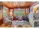 Bright sunroom features wood paneling, wicker furniture, and a work area at 39200 Cook Brown Rd, Punta Gorda, FL 33982