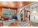 Sunroom with wood paneling, comfortable seating, and a view of the backyard at 39200 Cook Brown Rd, Punta Gorda, FL 33982