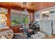 Sunroom has wood paneling, comfortable seating and a home office space at 39200 Cook Brown Rd, Punta Gorda, FL 33982