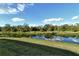 Tranquil backyard featuring a pond and reflecting trees at 4422 Legacy Ct, Sarasota, FL 34241